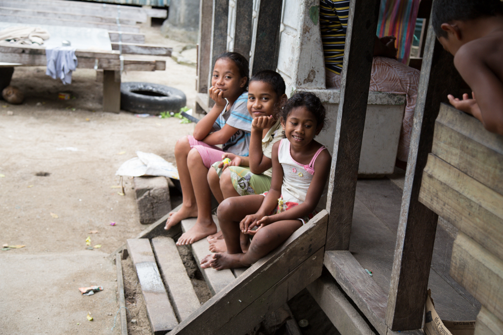 three islander kids sitting on a porch step