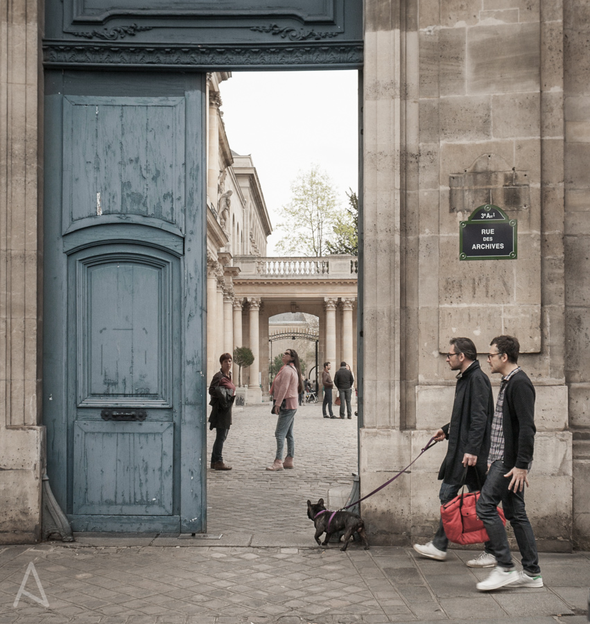 two nerdy guys walking their little dog in Paris rue des Archives